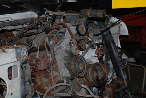 1996 Ford Bronco - Close-up view of a heavily rusted engine and its associated parts.