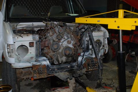 1996 Ford Bronco - The engine bay of a van is shown with the engine removed, revealing the internal structure.