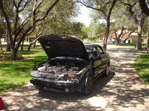 1996 Ford F-150 - Car with hood open, bumper removed, parked on a driveway under trees.