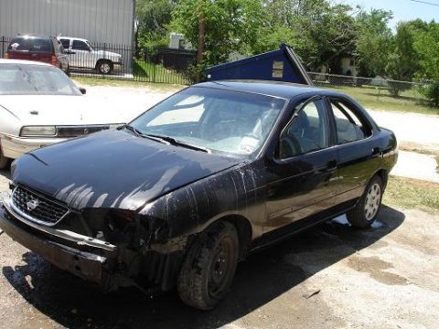 1996 Ford F-150 - This black sedan has significant damage to its front end and appears to be in a state of disrepair.