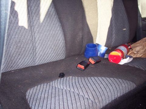 1993 Ford Probe - The interior of a vehicle shows seatbelt buckles, blue cups, and a fire extinguisher on the seats.