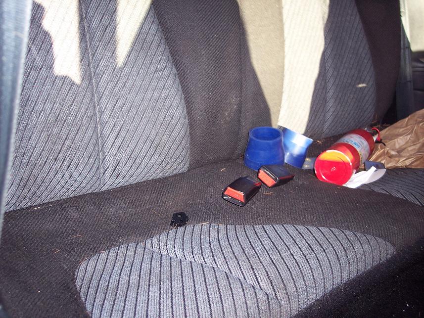 Interior seats with seatbelt buckles, blue cups, and a fire extinguisher
