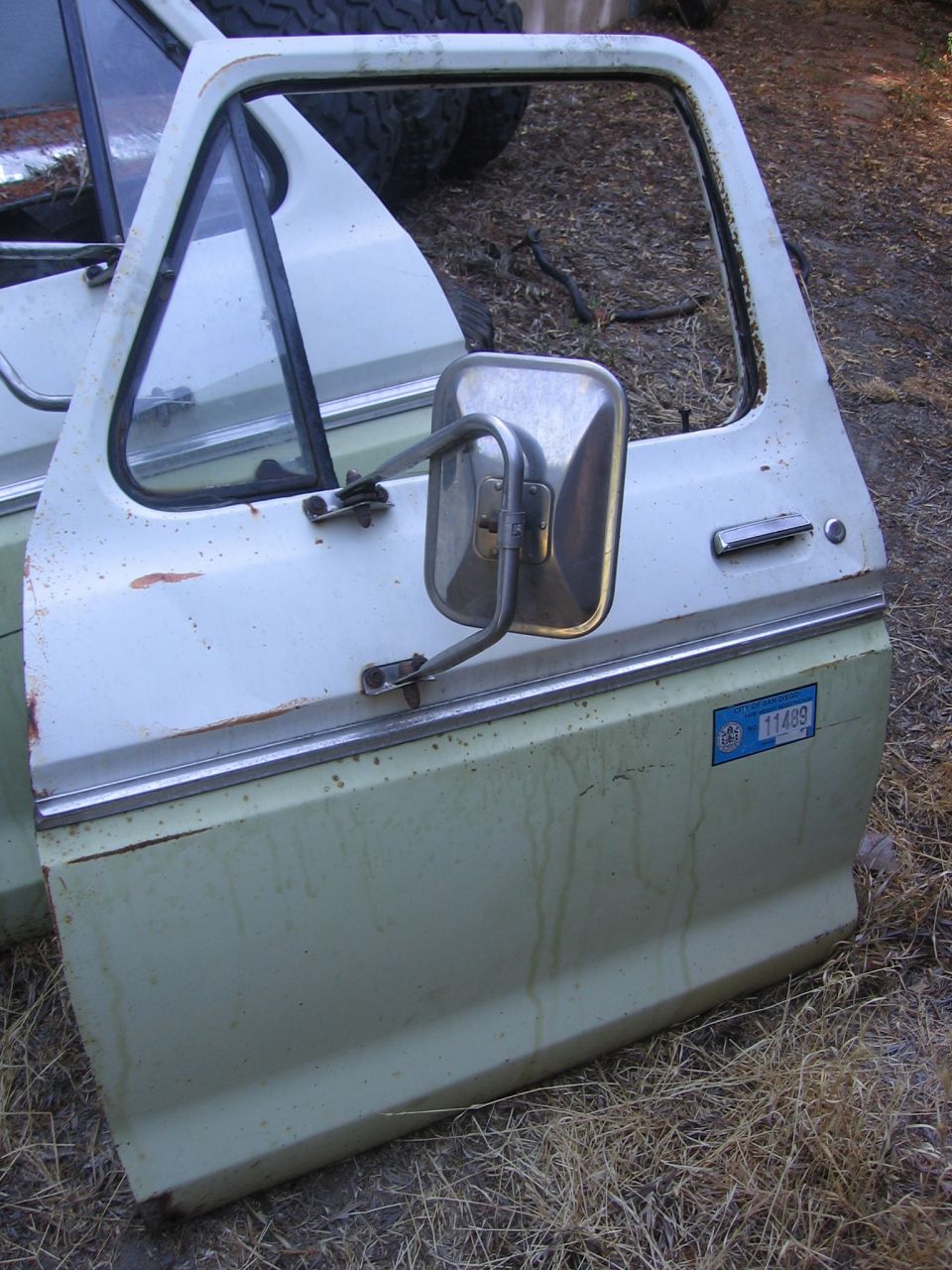Truck door with side mirror, showing a blue sticker with '11499' on it