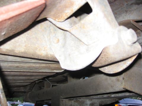 1989 Ford Bronco - Underside view of heavily rusted truck frame and suspension parts.