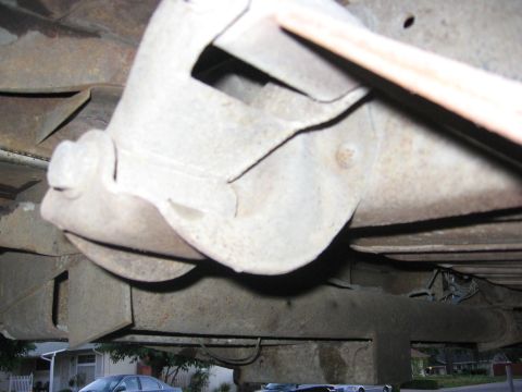 1989 Ford Bronco - The underside of a vehicle, with visible rust and suspension parts, is pictured from a low angle.