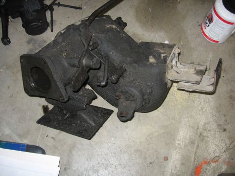 1989 Ford Bronco - Transfer case assembly, likely from a 4x4 vehicle, sitting on a concrete floor.
