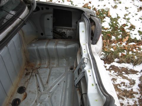 1992 Ford Crown Victoria - The interior of a car trunk is shown, with the lid open, revealing a bare metal floor and sides.