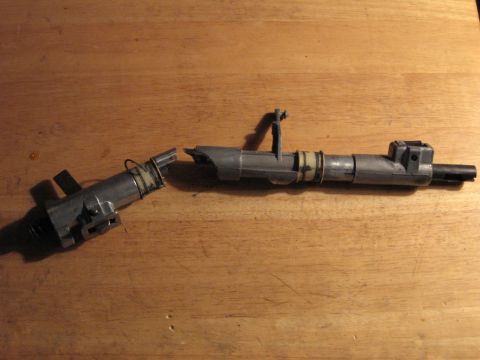 1992 Ford Crown Victoria - A broken fuel injector lies on a wooden surface, indicating a part failure.