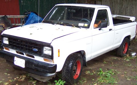 1978 Ford Bronco - This white Ford Ranger pickup truck features red-painted rims and appears to be parked in a yard.