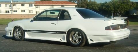 1987 Ford Thunderbird - This 1987 Ford Thunderbird features a custom body kit and black racing stripes, giving it a unique sporty appearance.