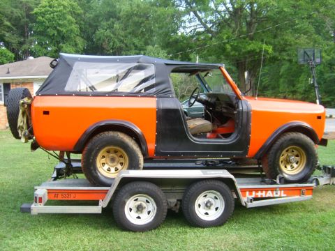 1994 Ford Bronco - Orange and black International Harvester Scout II is loaded onto a U-Haul trailer.