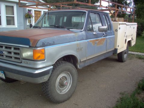 1993 Ford Bronco - This Ford F-Series truck features a utility bed and shows signs of wear and tear.