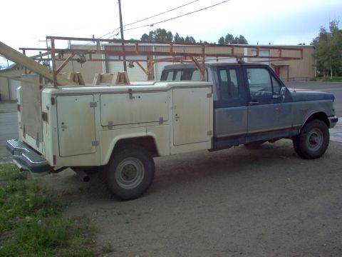 1993 Ford Bronco - This truck has a utility body with multiple compartments and a rack system mounted on top.