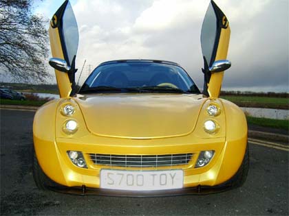 1998 Ford Crown Victoria - This yellow smart car features distinctive butterfly doors and a custom license plate.