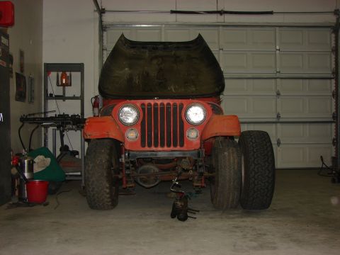 1978 Ford Bronco - Front view of an orange Jeep CJ5 with its hood raised, parked inside a garage.