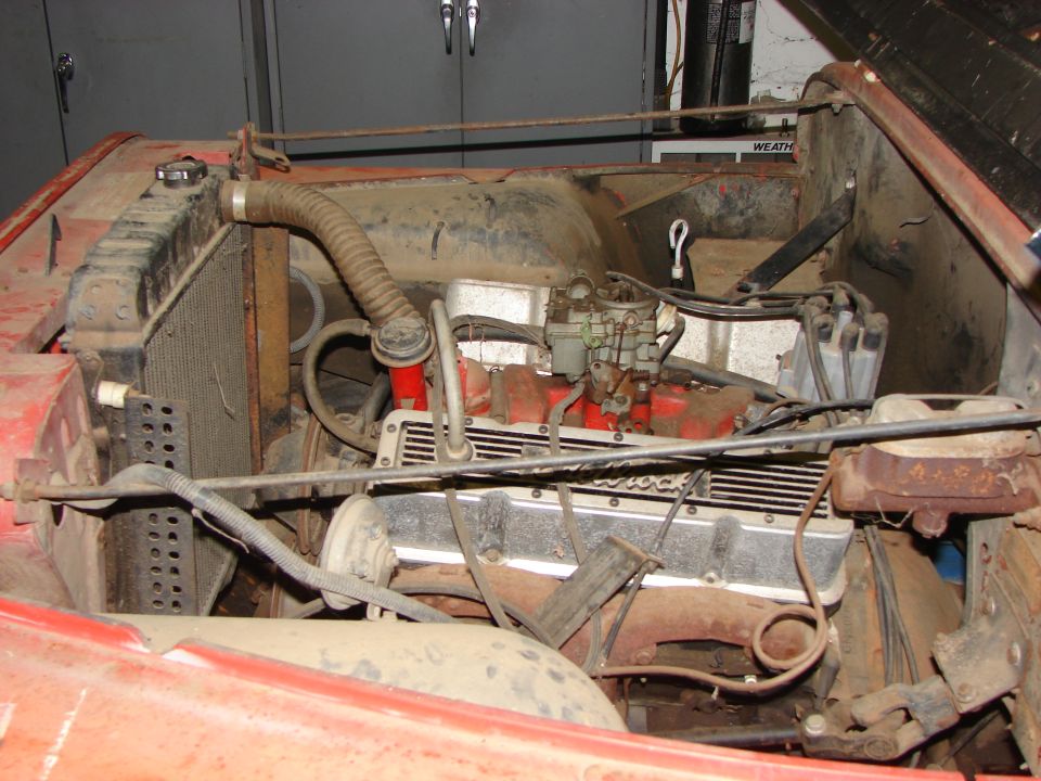 Engine bay with V8 engine, carburetor, radiator, and distributor visible