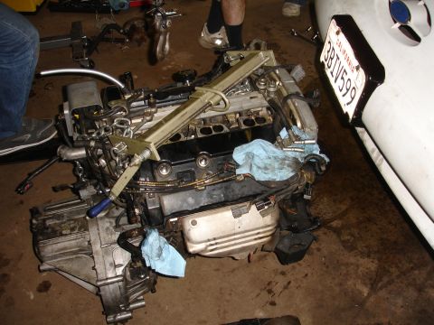 1993 Ford Taurus - Engine assembly is being worked on in a garage setting, with a white vehicle fender visible on the right.