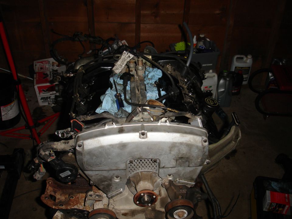 Engine assembly with wiring harness and fuel injectors, covered in blue shop towels