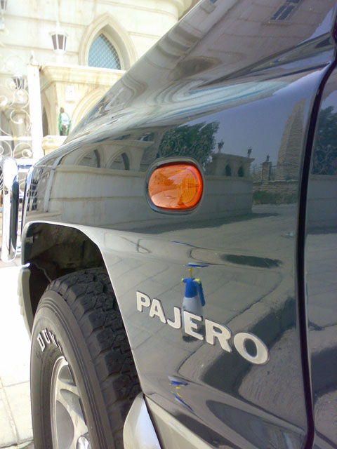 2000 Mitsubishi Montero - Side view of a dark SUV, identified by its PAJERO badge and amber marker light.