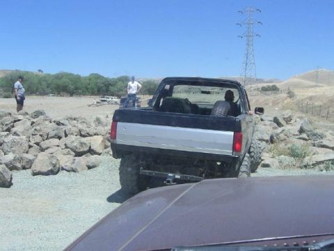 1989 Ford Bronco - A 1989 Ford Bronco navigates a rocky obstacle course on a sunny day.