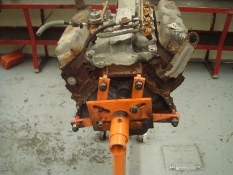 1996 Ford Bronco - A heavily rusted engine is mounted on an orange engine stand, showing significant wear and tear.