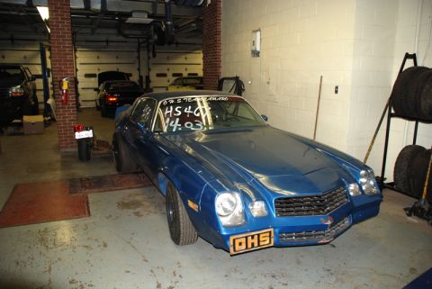 1996 Ford Bronco - A blue Chevrolet Camaro drag car is parked in a garage, displaying racing times on its windshield and an 'OHS' plate on the front bumper.
