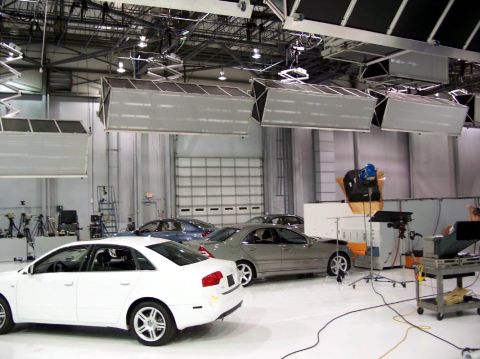 1971 Ford Ranchero - A studio environment is set up for a photoshoot with several cars and professional lighting equipment.