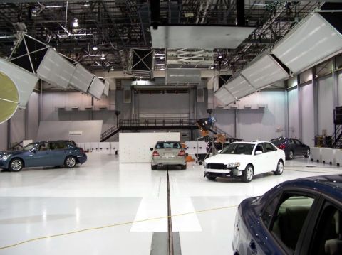 1971 Ford Ranchero - Multiple vehicles are positioned on a white floor within a studio environment, under large lighting equipment.