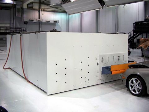 1971 Ford Ranchero - A silver car is positioned in front of a large white testing apparatus within a spacious facility.