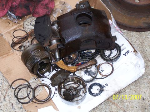 1979 Ford F-150 - A collection of disassembled brake caliper and bearing components lies on a cardboard surface.
