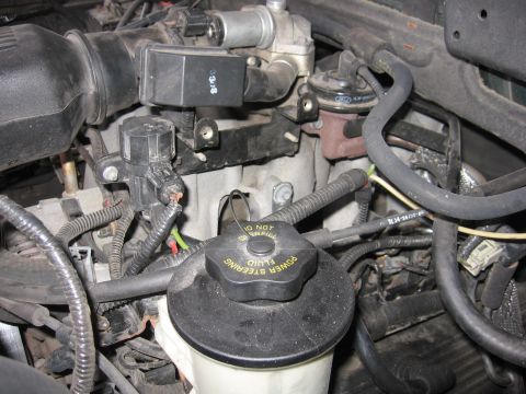 2001 Ford F-150 - Close-up of an engine bay, focusing on the power steering fluid reservoir cap with warning text.