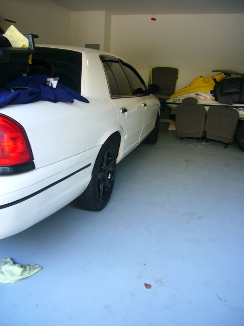 2000 Ford Crown Victoria - Rear view of a white 2000 Ford Crown Victoria parked in a garage with other items.