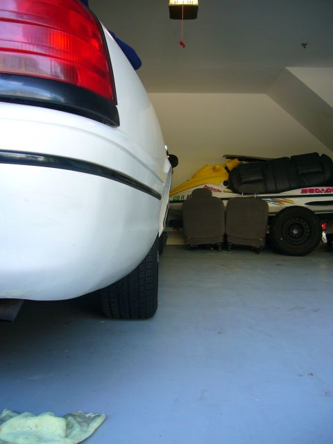 2000 Ford Crown Victoria - Rear quarter view of a white 2000 Ford Crown Victoria, showing the wheel and taillight assembly.