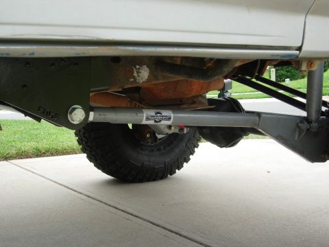 1995 Ford Bronco - Close-up view of the modified suspension and undercarriage of a silver vehicle.