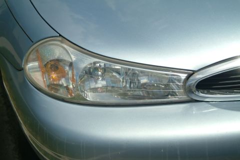 1999 Ford Crown Victoria - Close-up of a car's front end, showing the headlight and part of the grille.