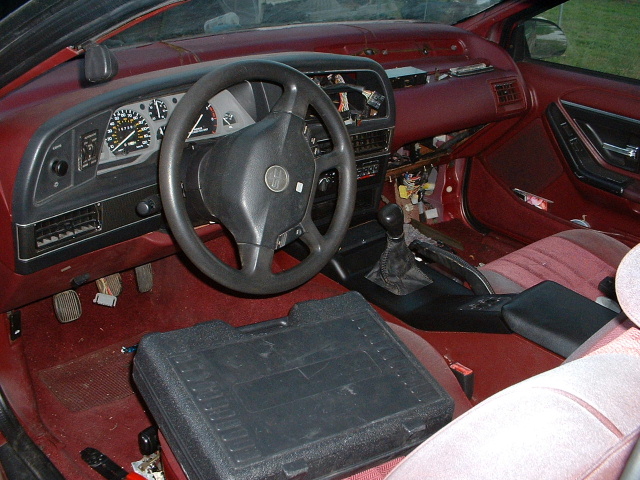 1989 Ford Thunderbird interior with red upholstery and a black steering wheel