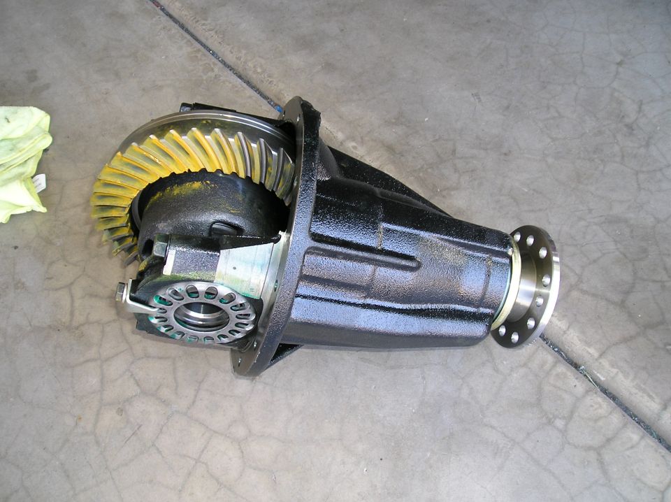 Removed differential third member with yellow marking compound on ring gear, on concrete floor