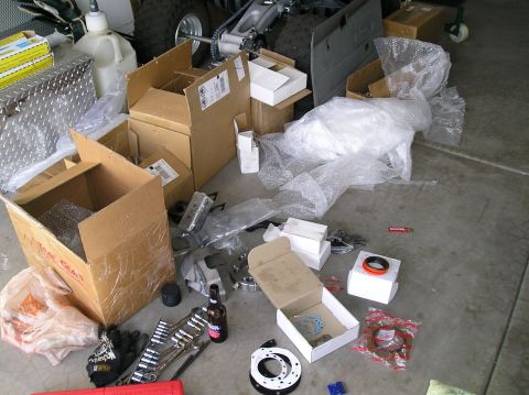 1986 Toyota Hilux - Various automotive parts and tools are laid out on a concrete garage floor.