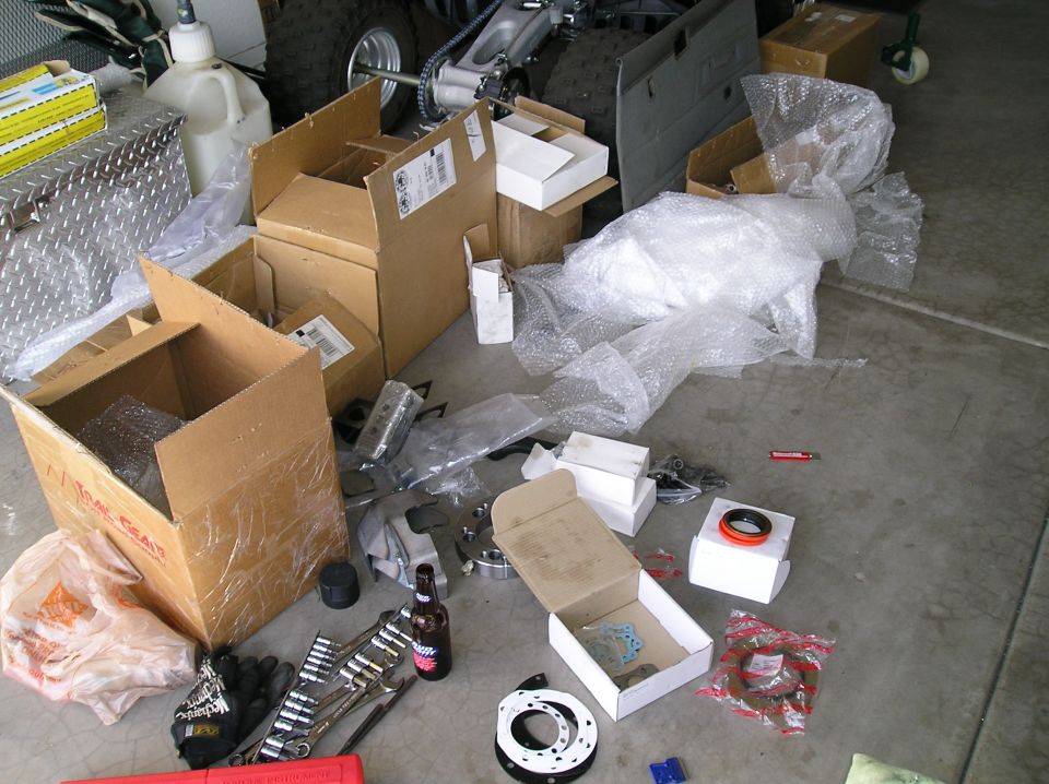 Boxes, tools, and automotive parts scattered on a garage floor