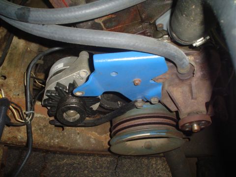 1967 Ford F-250 - Engine bay view showing an alternator, belt-driven pulleys, and associated hoses and wiring.