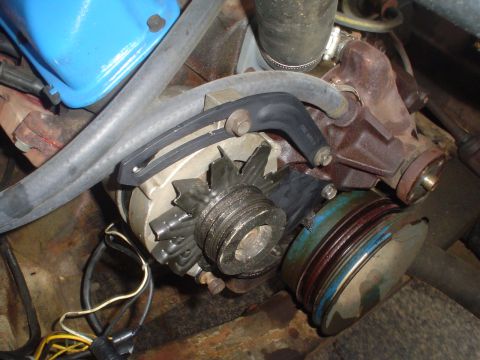 1967 Ford F-250 - Close-up view of engine components, including an alternator and pulleys, with visible hoses and wiring.