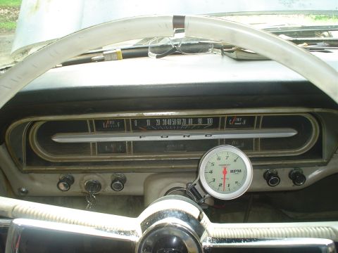 1967 Ford F-250 - The interior of a 1967 Ford F-250 shows the original dashboard gauges and an aftermarket tachometer.