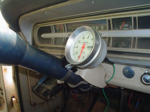 1967 Ford F-250 - Close-up of an aftermarket tachometer installed on a vehicle's dashboard.