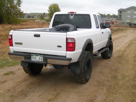 1996 Ford Bronco - This white Ford Ranger pickup truck is shown from the rear, with a spare tire visible in the bed.