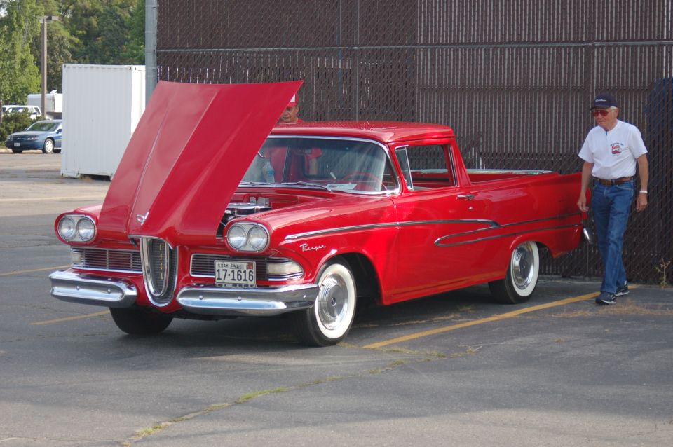 Red 1958 Edsel Pacer pickup truck with hood open, man standing next to it