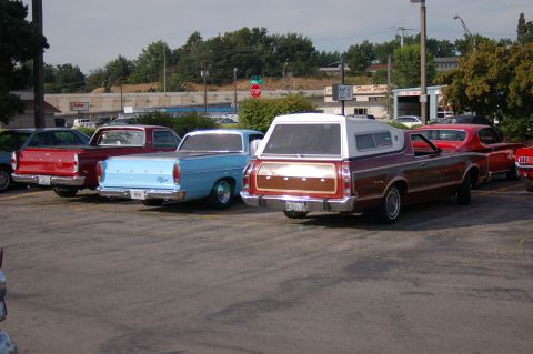 1967 Ford Ranchero - Multiple Ford Rancheros are parked in a lot, including a brown 1968 model with a camper shell.
