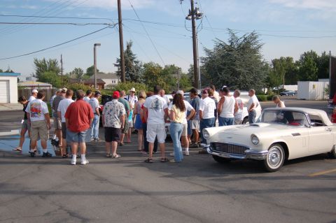 1967 Ford Ranchero - A group of people admire a white 1957 Ford Thunderbird convertible at an outdoor event.