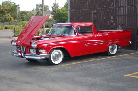 1967 Ford Ranchero - This red pickup truck has its hood open, revealing the engine bay and chrome grille.