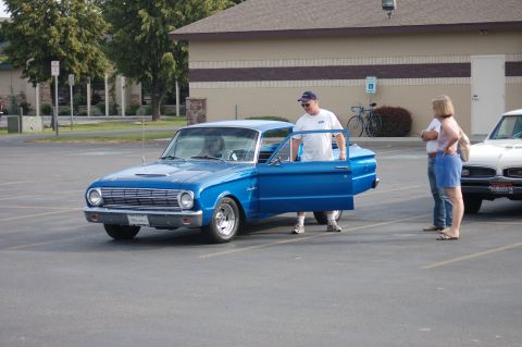 1967 Ford Ranchero - A blue classic car, possibly a 1963 Ford Falcon, is parked in a lot with its door open.