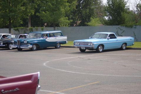 1967 Ford Ranchero - Two classic vehicles are parked in a lot, with a third vehicle partially visible in the foreground.